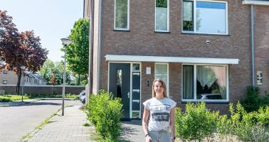 jonge vrouw met hondjes voor huis 