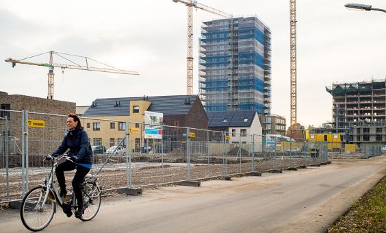 Vrouw fietst in nieuwbouwwijk