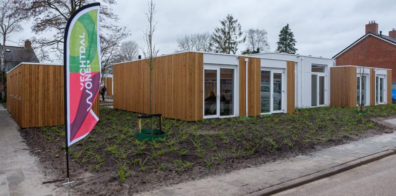Tiny houses met groenstrook in aanbouw en een vlag van Vechtdal Wonen