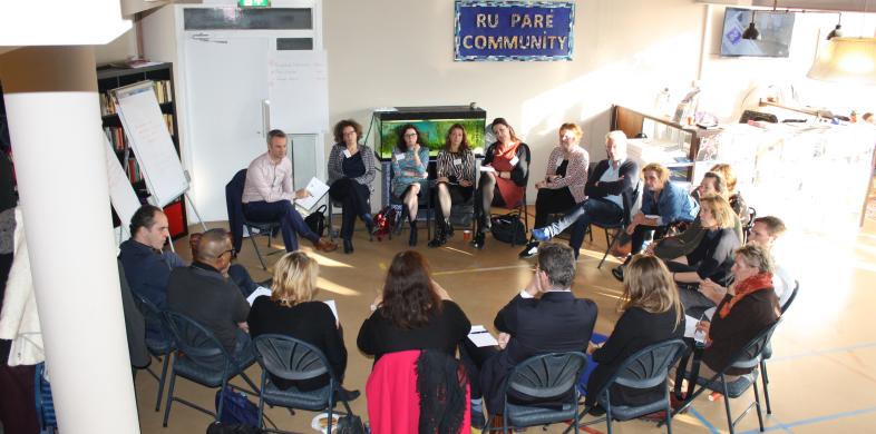 Groep mensen op stoelen in een kring
