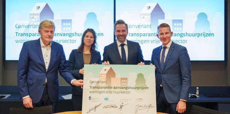 Martin van Rijn (Aedes), Judith Norbart-ten Hoor (IVBN), Hugo de Jongen (Minister VRO) en Jack de Vries (VastgoedBelang) houden een getekend convenant vast