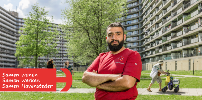 Man voor flatgebouwen met logo van corporatie Havensteder
