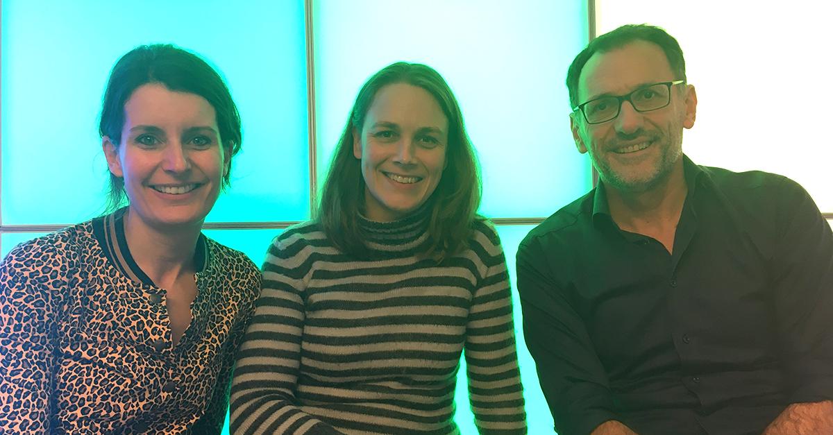 Drie personen voor een groene lichtwand