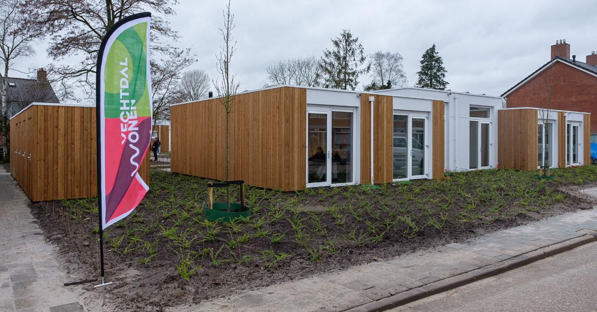 Tiny houses met groenstrook in aanbouw en een vlag van Vechtdal Wonen