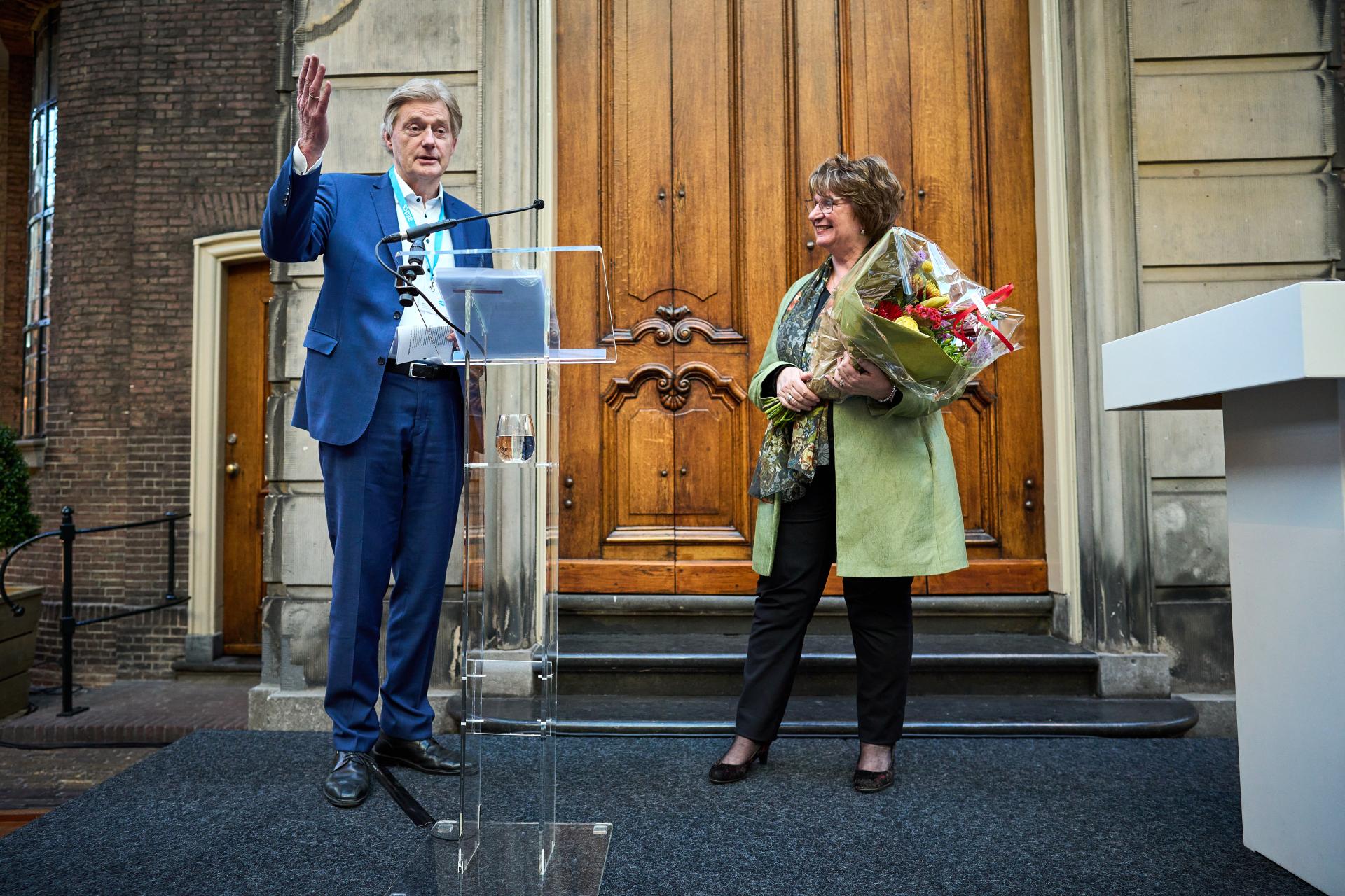 Voorzitter Martin van Rijn overhandigt bloemen aan Mariëtte Hamer Voorzitter van de Sociaal-Economische Raad